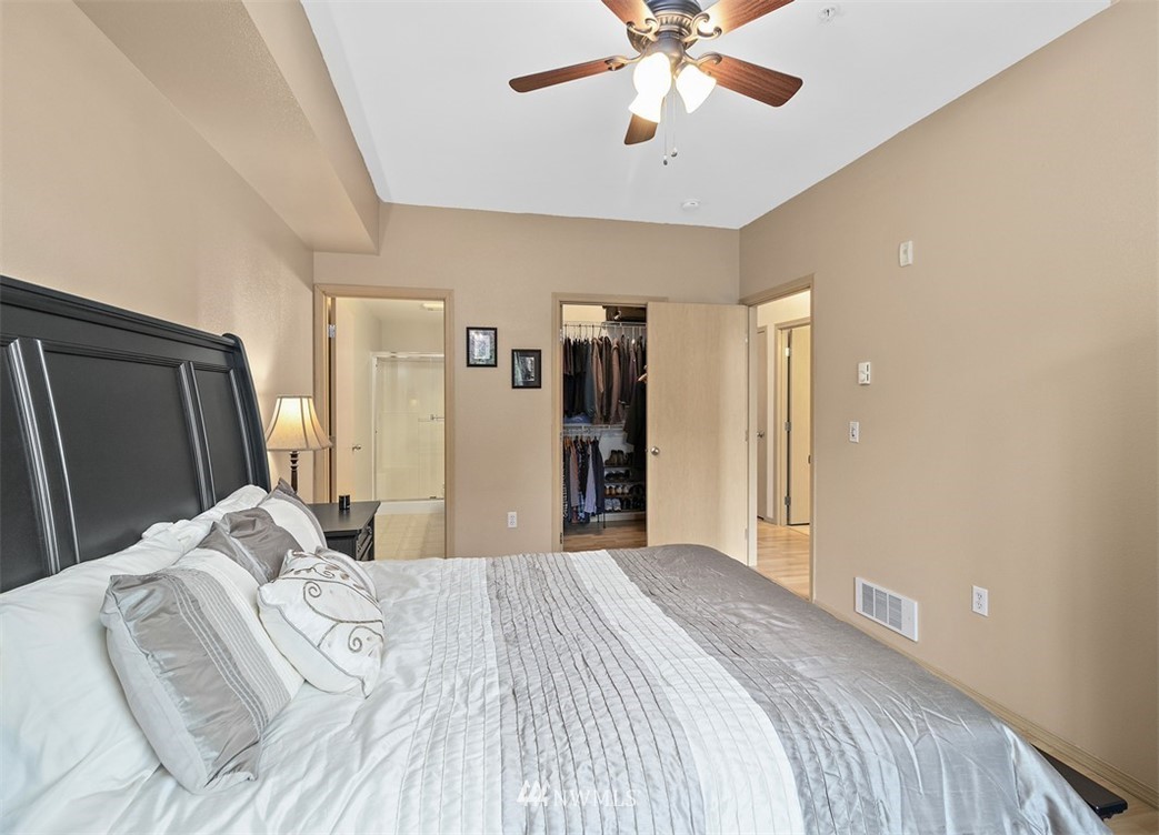 3012 Southeast 8th Place, Unit 1117 Renton, WA 98058 - Photo 16 of 40 a bedroom with a large bed and a chandelier