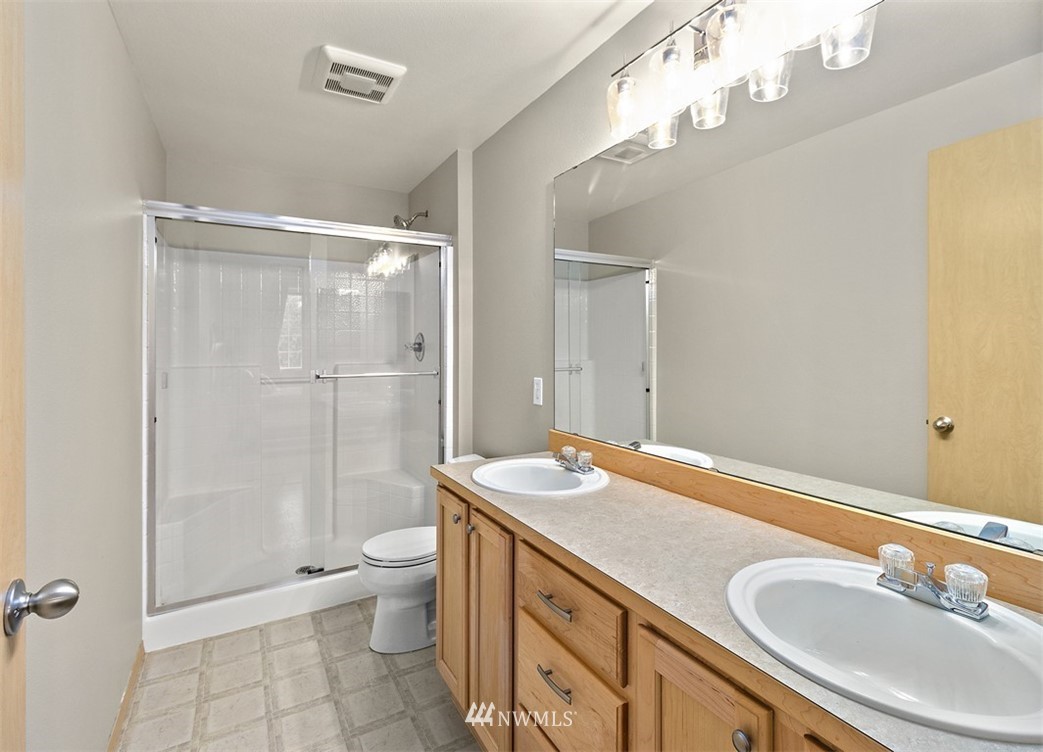 3012 Southeast 8th Place, Unit 1117 Renton, WA 98058 - Photo 18 of 40 a bathroom with a granite countertop sink toilet mirror and shower