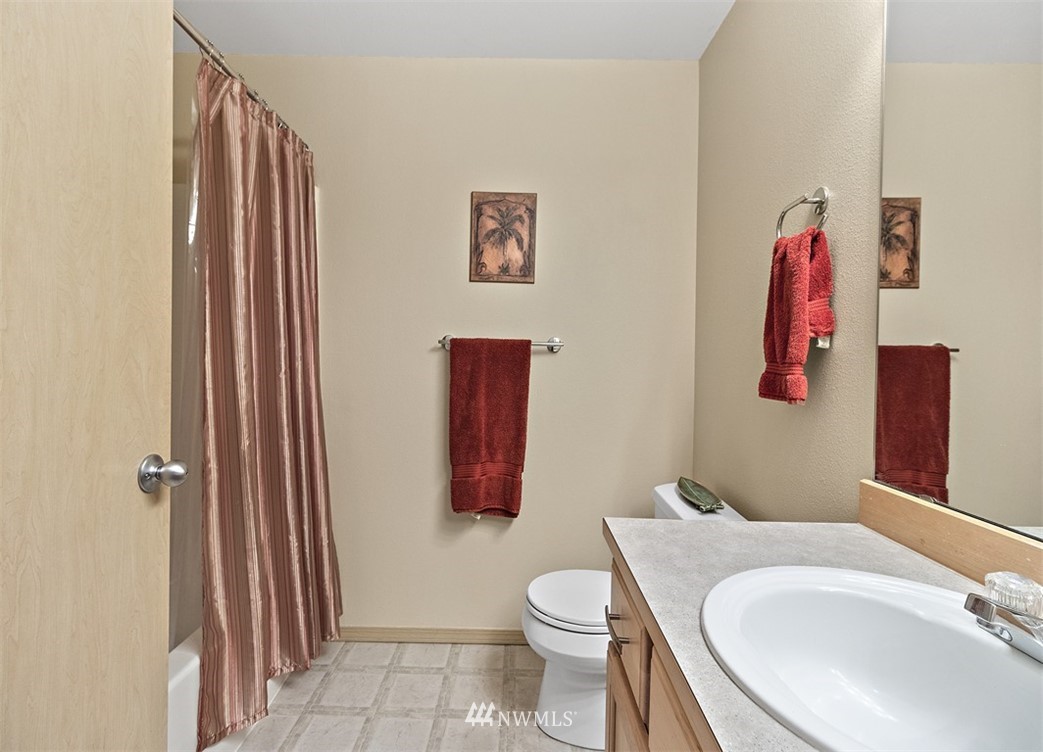 3012 Southeast 8th Place, Unit 1117 Renton, WA 98058 - Photo 23 of 40 a bathroom with a toilet a sink and curtain
