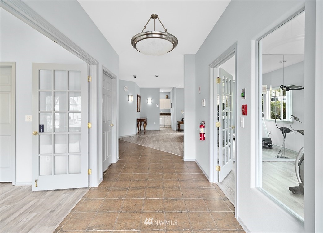 3012 Southeast 8th Place, Unit 1117 Renton, WA 98058 - Photo 30 of 40 a view of a hallway with wooden floor and windows