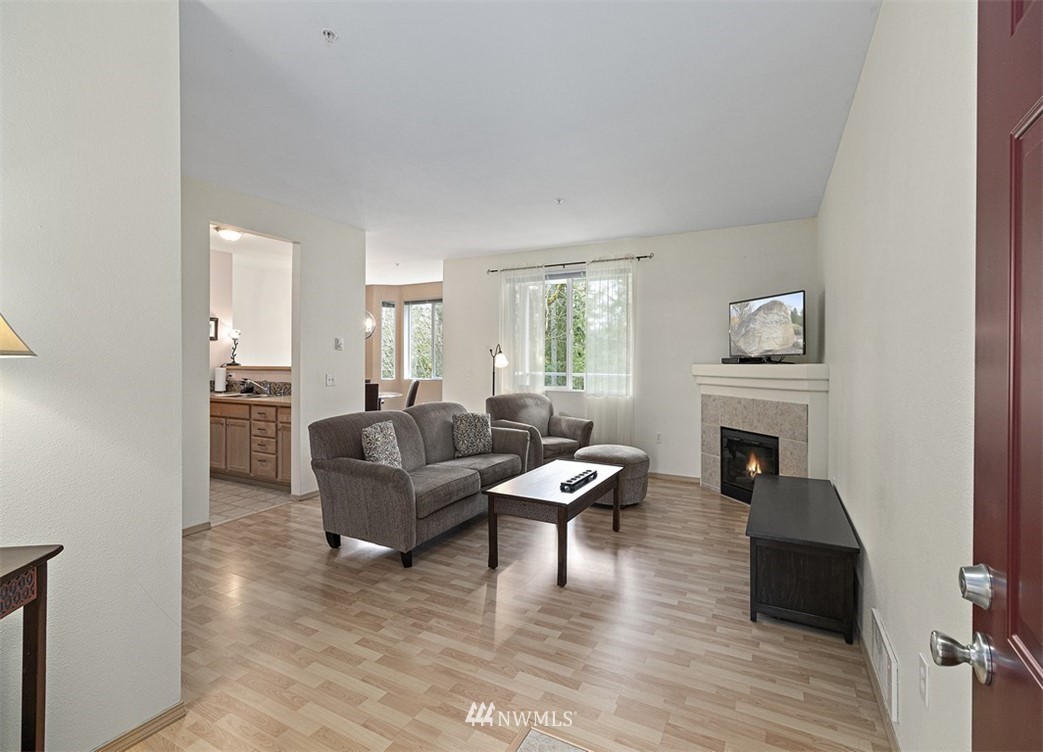 3012 Southeast 8th Place, Unit 1117 Renton, WA 98058 - Photo 4 of 40 a living room with furniture and a fireplace