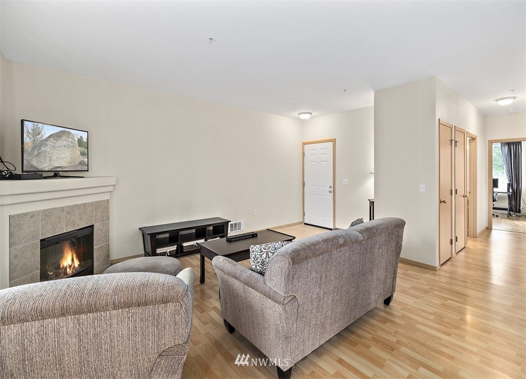 3012 Southeast 8th Place, Unit 1117 Renton, WA 98058 - Photo 7 of 40 a living room with furniture and a fireplace