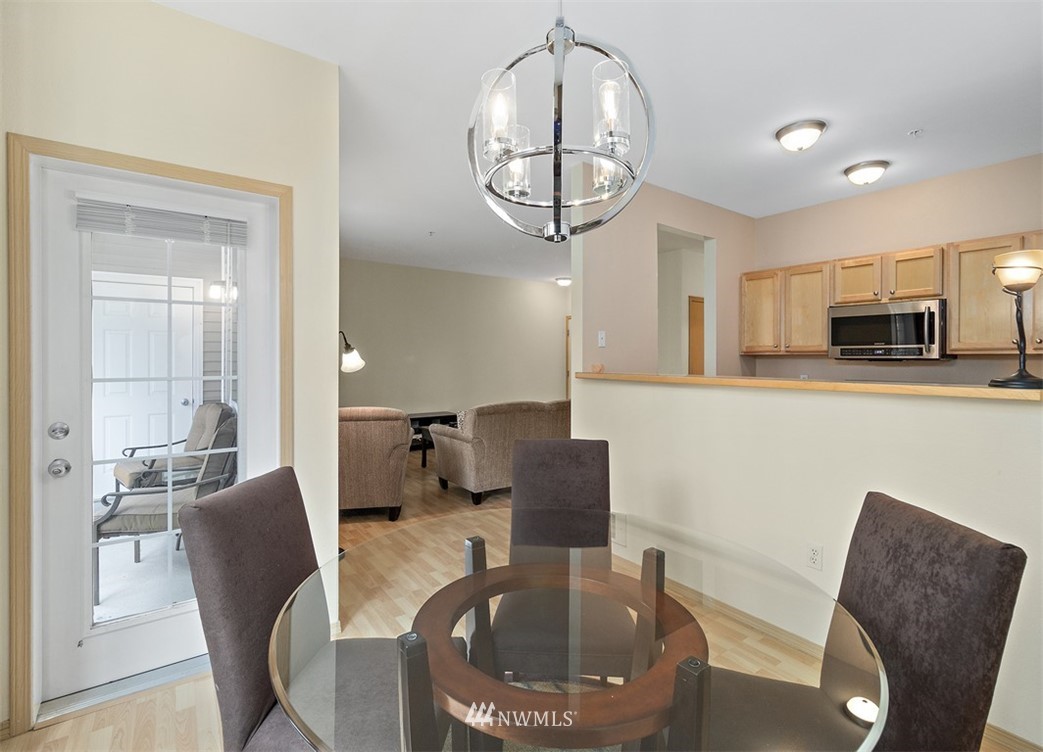 3012 Southeast 8th Place, Unit 1117 Renton, WA 98058 - Photo 9 of 40 a dining room with furniture a livingroom and chandelier