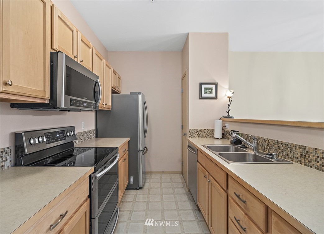 3012 Southeast 8th Place, Unit 1117 Renton, WA 98058 - Photo 10 of 40 a kitchen with a sink stove and refrigerator
