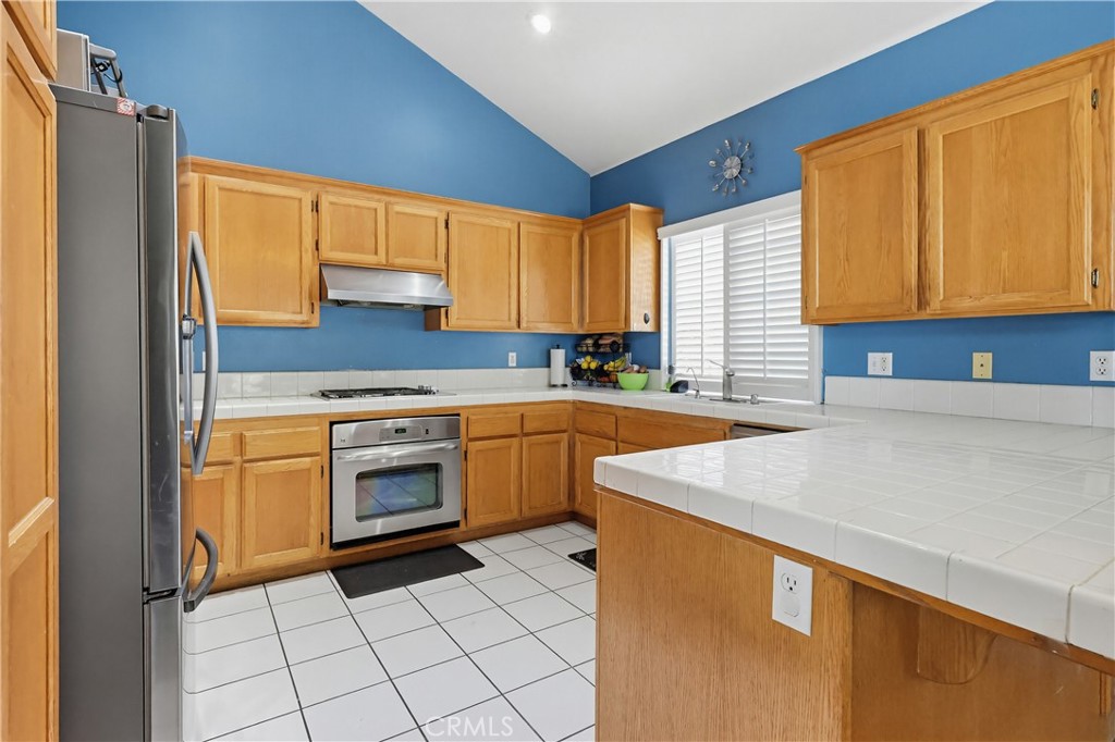 7735 Ridgeview Lane Whittier, CA 90606 - Photo 14 of 47 a kitchen with a sink a stove top oven and cabinets
