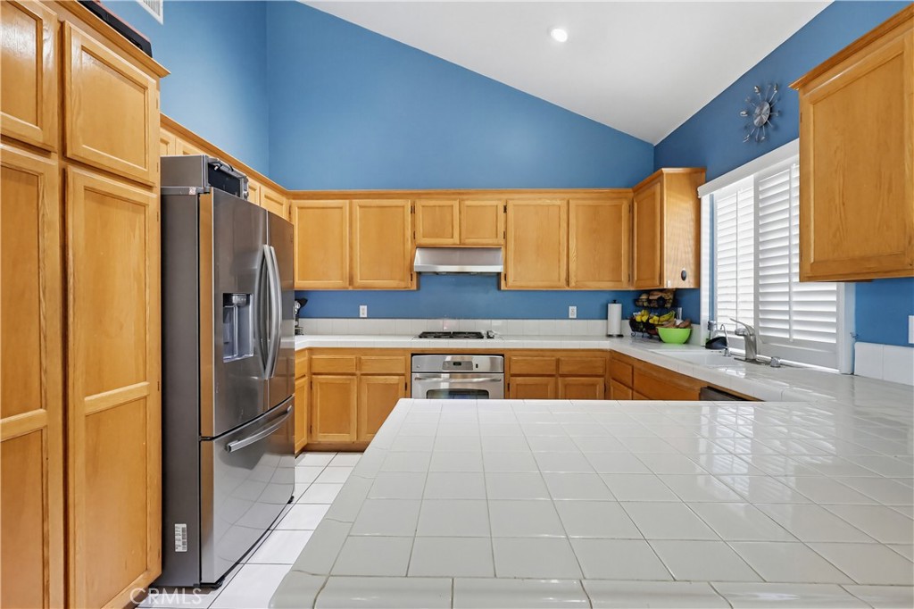 7735 Ridgeview Lane Whittier, CA 90606 - Photo 15 of 47 a kitchen with a sink a counter top space cabinets stainless steel appliances and a window