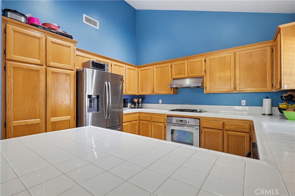 7735 Ridgeview Lane Whittier, CA 90606 - Photo 16 of 47 a kitchen with stainless steel appliances a refrigerator sink and cabinets