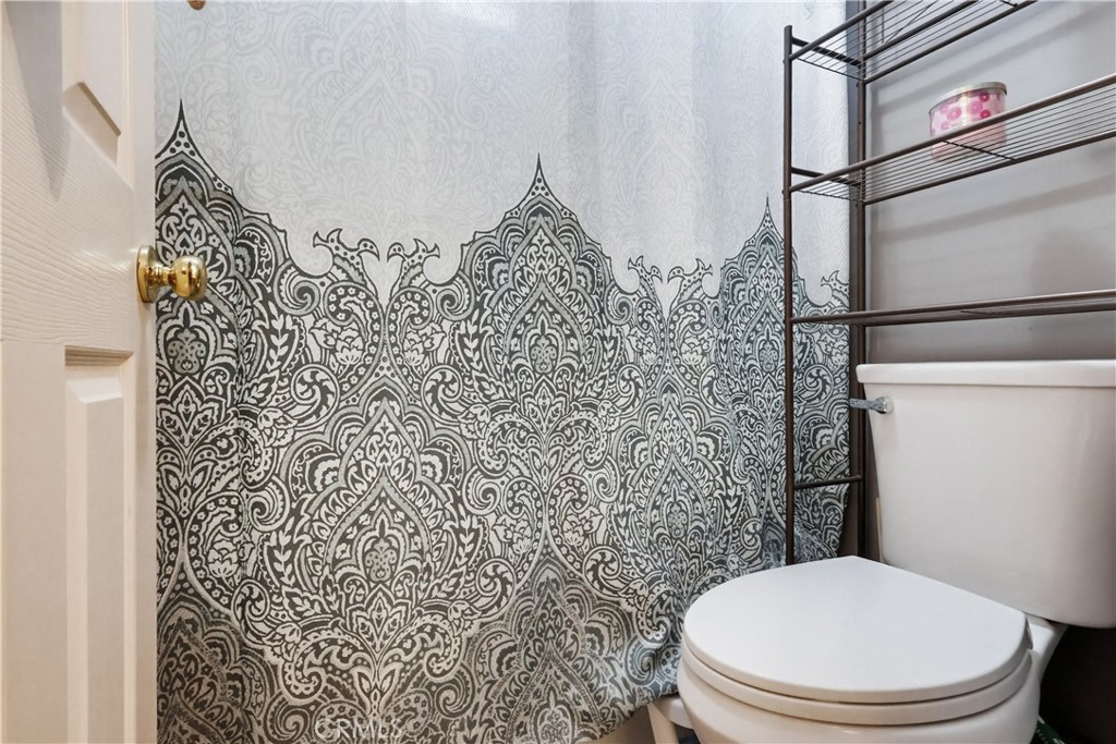 7735 Ridgeview Lane Whittier, CA 90606 - Photo 27 of 47 a bathroom with a toilet and a shower curtain