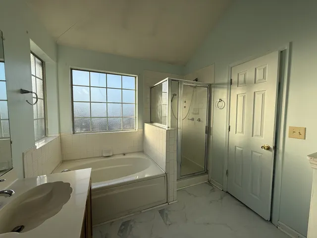 a bathroom with a granite countertop sink a toilet and shower