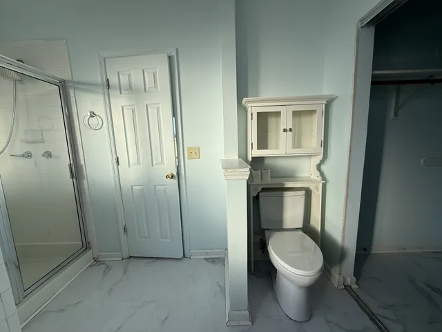 a bathroom with a toilet and a shower