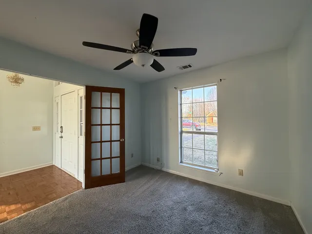 a view of a livingroom with a ceiling fan and window