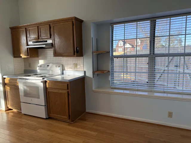 a kitchen with kitchen island granite countertop a sink cabinets and stainless steel appliances