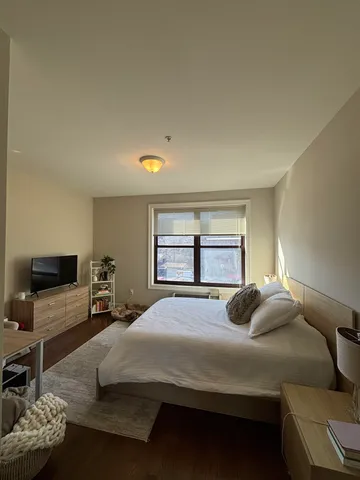 a bedroom with a bed window and couch