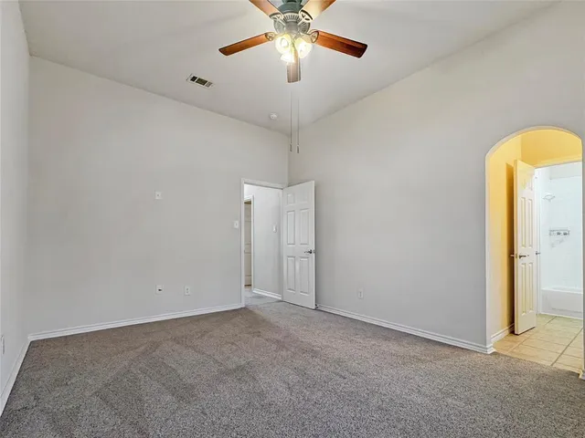 an empty room with closet and a chandelier fan