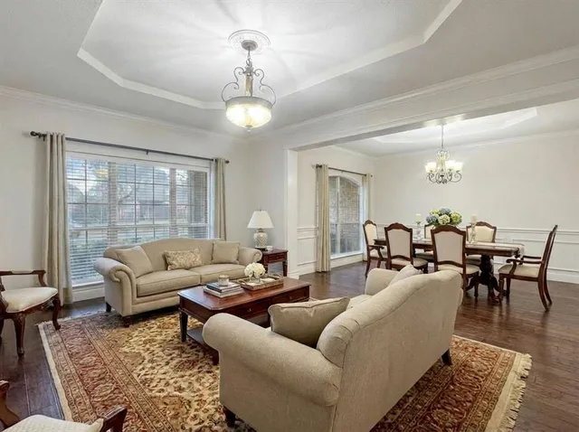 a living room with furniture potted plant and a large window