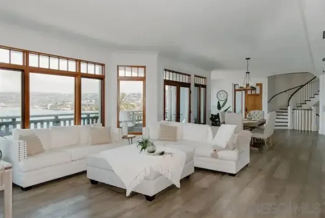 a living room with furniture wooden floor and floor to ceiling window