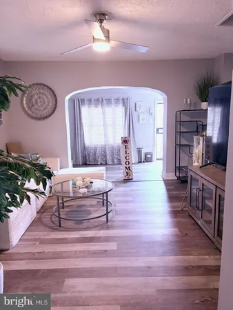 a living room with furniture and a wooden floor