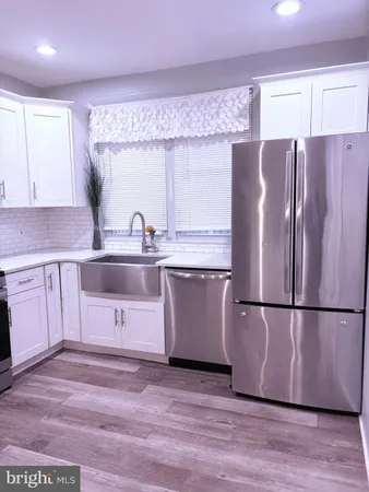 a kitchen with stainless steel appliances granite countertop a refrigerator a sink a stove a microwave and cabinets