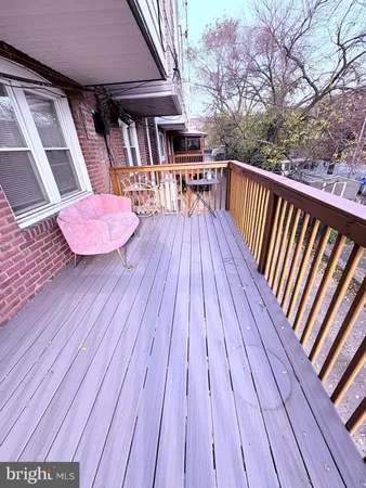 a balcony with wooden floor table and chairs