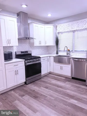 a large kitchen with granite countertop a stove top oven sink and cabinets