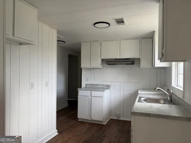 a kitchen with a sink a stove and cabinets
