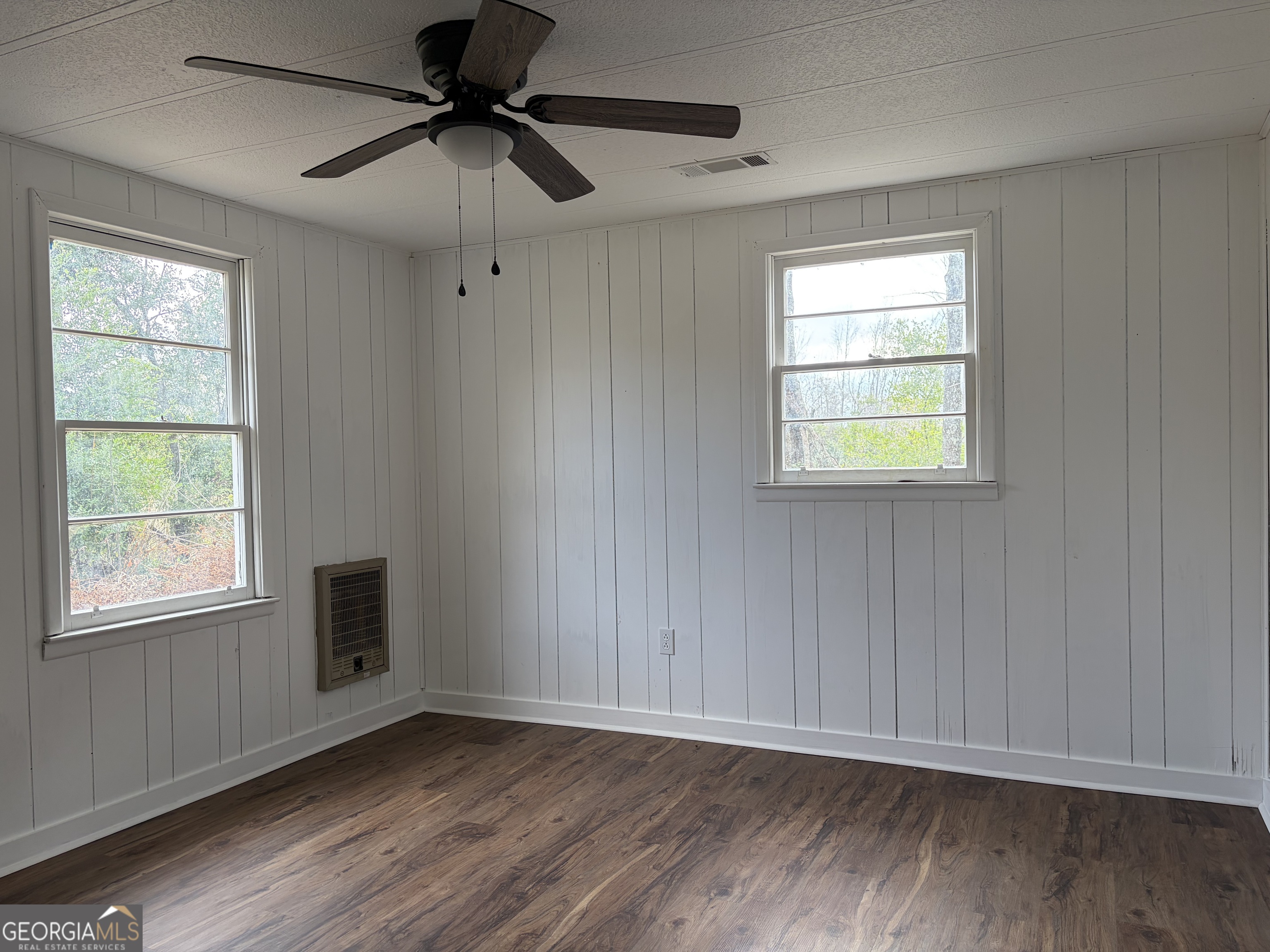 184 Belvue Avenue Lyons, GA 30436 - Photo 9 of 11 a view of an empty room with a window and wooden floor