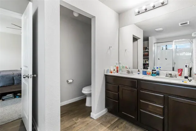a bathroom with a double vanity sink toilet and a mirror