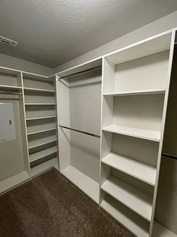a view of walk in closet with empty racks