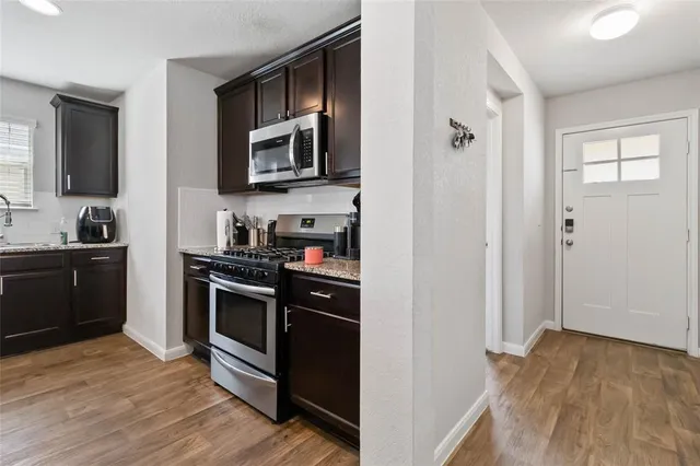 a kitchen with stainless steel appliances granite countertop a refrigerator and a stove top oven