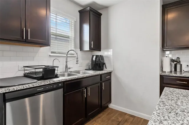 a kitchen with granite countertop a sink stove and cabinets