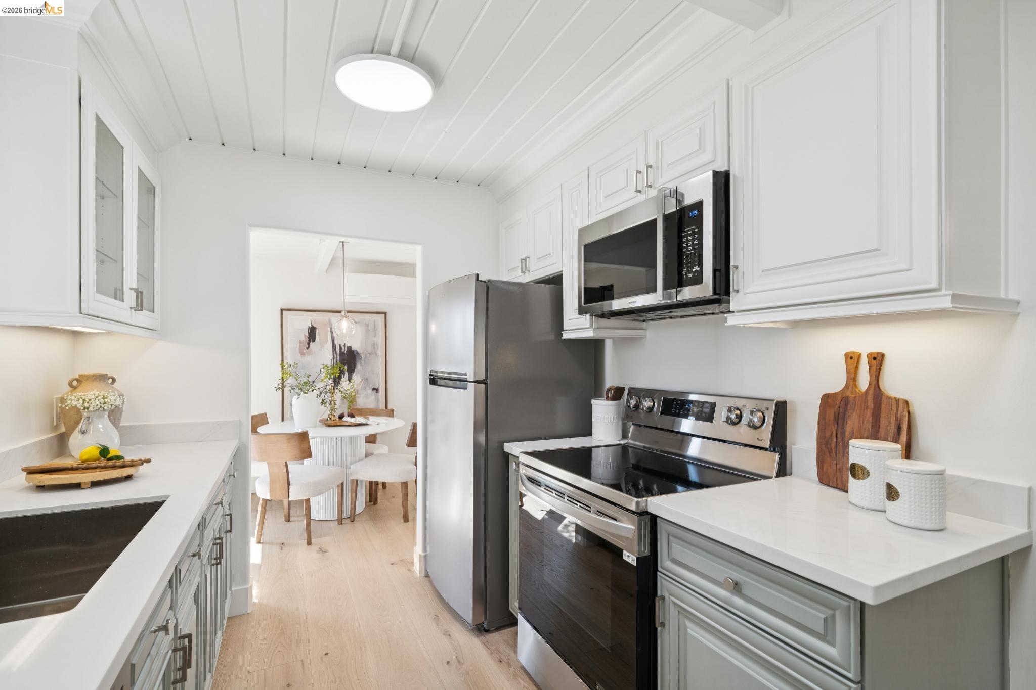 1321 Sunset Loop Lafayette, CA 94549 - Photo 11 of 49 Stainless steel appliances, white wood-paneled ceiling, white upper cabinetry, light gray lower cabinetry, and light wood-finish flooring