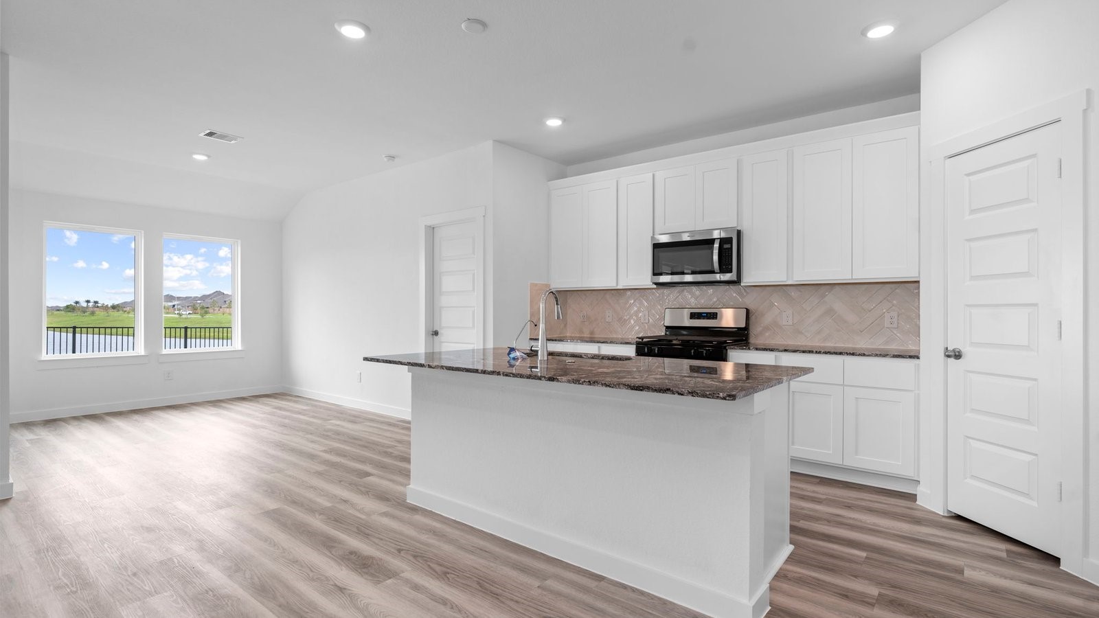 13 Robin Court Angleton, TX 77515 - Photo 5 of 27 a kitchen with granite countertop a stove a sink and a microwave