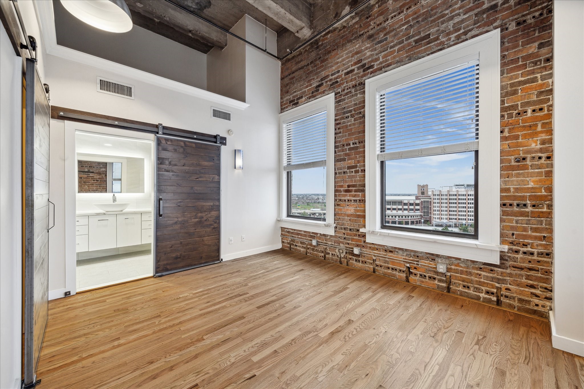 915 Franklin Street, Unit 9I Houston, TX 77002 - Photo 12 of 23 a view of an empty room with a window and wooden floor