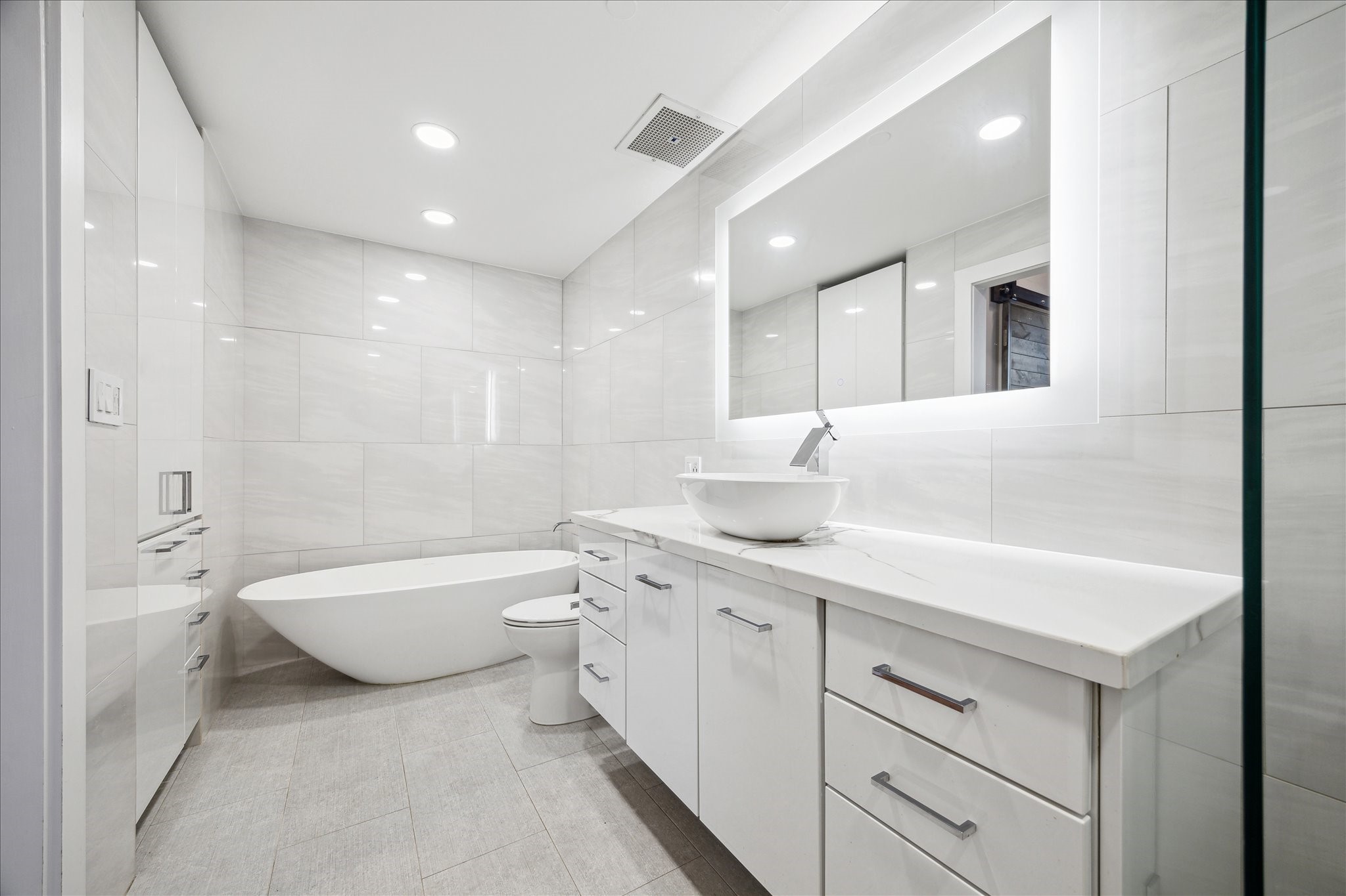915 Franklin Street, Unit 9I Houston, TX 77002 - Photo 15 of 23 a bathroom with a double vanity sink mirror bathtub and toilet