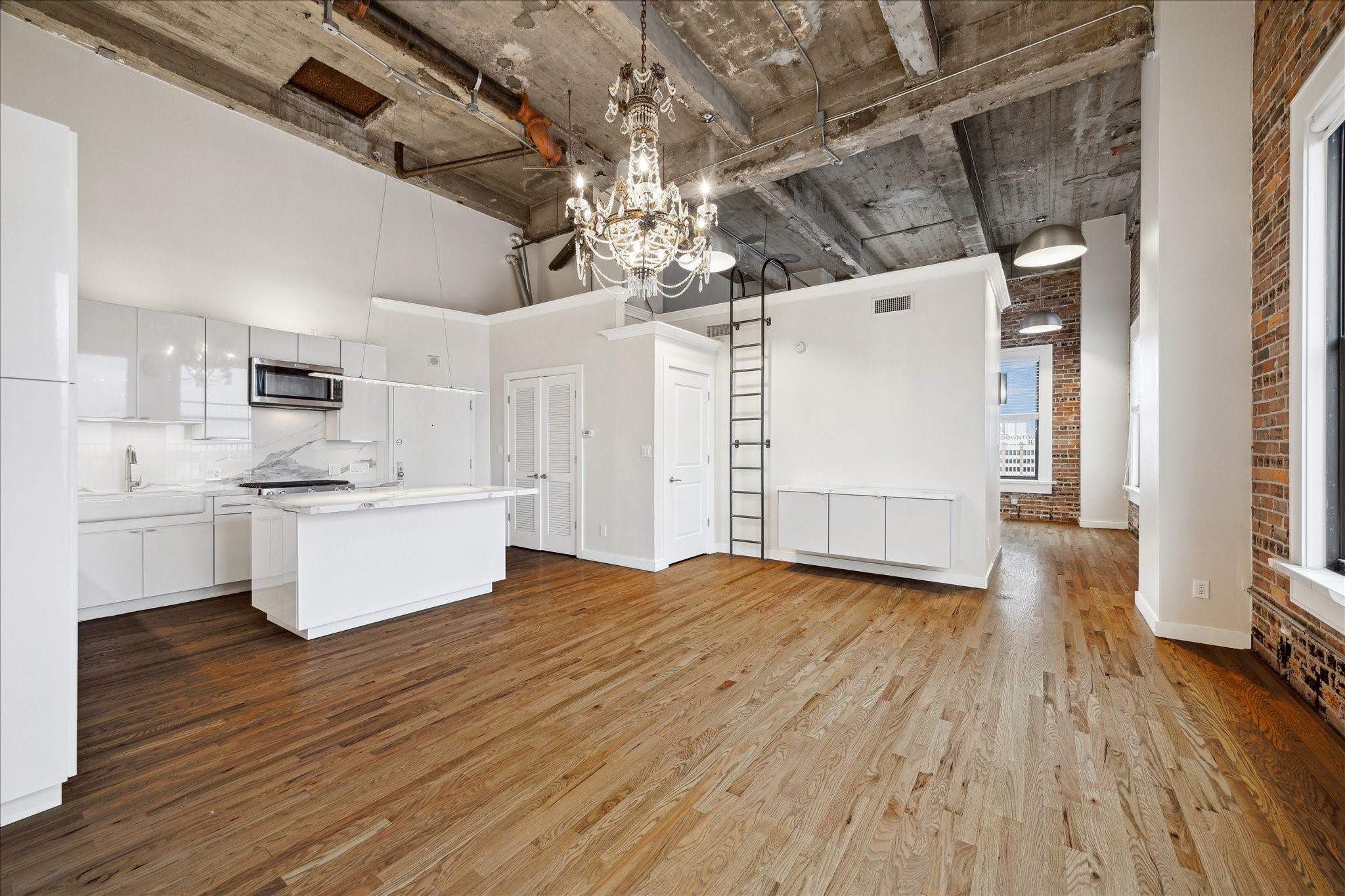 915 Franklin Street, Unit 9I Houston, TX 77002 - Photo 7 of 23 a kitchen with stainless steel appliances a white cabinets and wooden floors