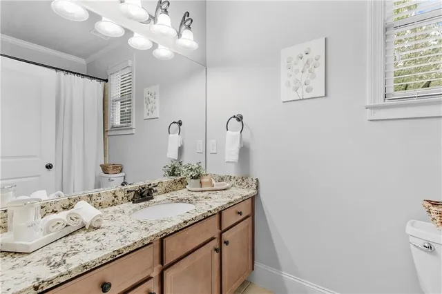 a kitchen with stainless steel appliances granite countertop a refrigerator a sink dishwasher a stove and white countertops with wooden floor