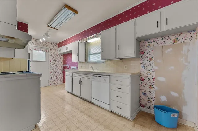 a kitchen with white cabinets and white appliances