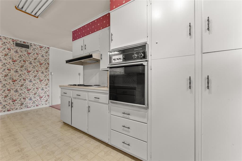 3216 MacArthur Drive Waco, TX 76708 - Photo 24 of 39 a kitchen with white cabinets and white appliances