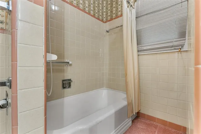 an empty room with chandelier fan and windows