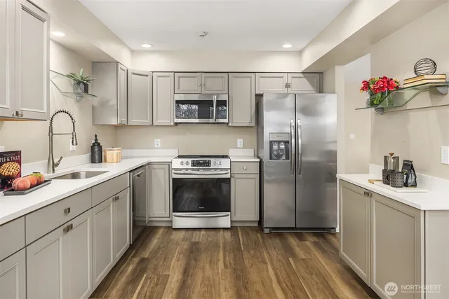 a kitchen with stainless steel appliances a sink cabinets and a refrigerator