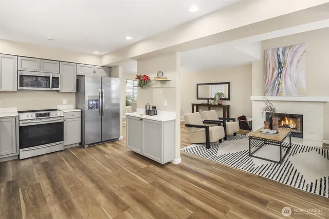 a kitchen with granite countertop a refrigerator and a stove top oven