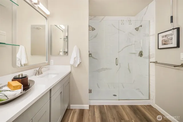 a bathroom with a granite countertop sink mirror and shower