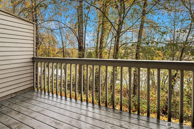 a view of a wooden balcony and trees