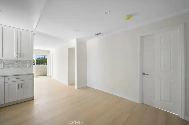 a view of a kitchen with an empty space and wooden floor