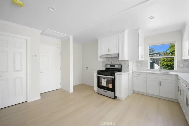 a kitchen with white cabinets and appliances