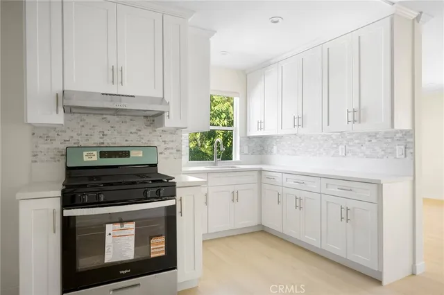 a kitchen with white cabinets and appliances