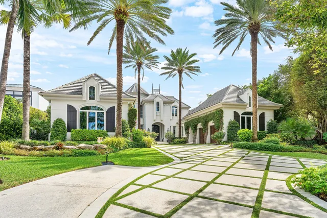 a front view of a house with a yard and potted plants