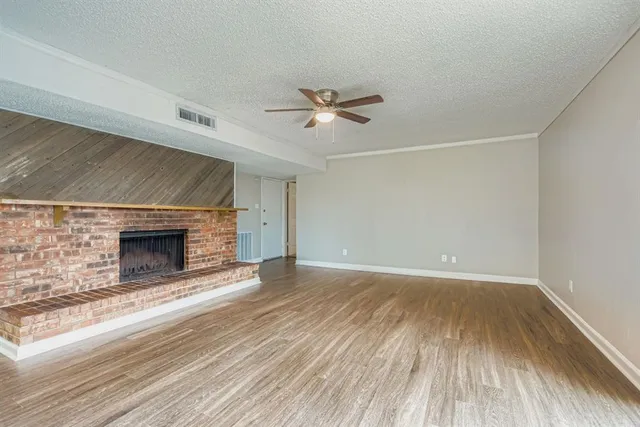 a view of empty room with wooden floor and fireplace