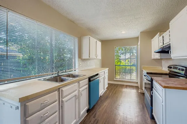 a kitchen with stainless steel appliances granite countertop a sink stove and cabinets
