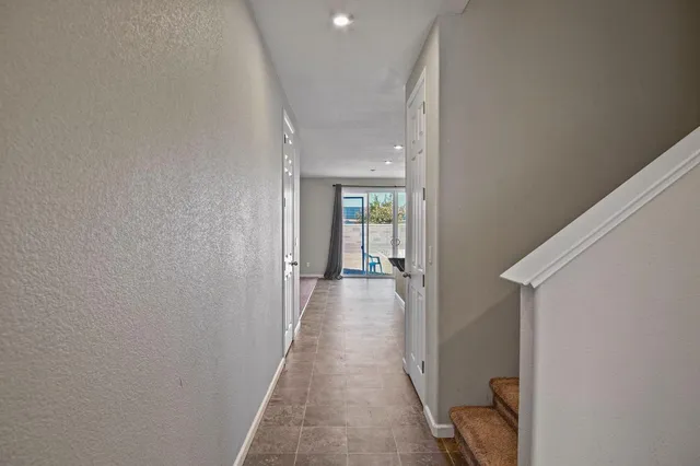 a view of a hallway with wooden floor and a living room